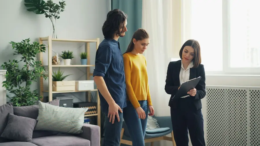 Advisor with a clipboard talking with a couple inside their home