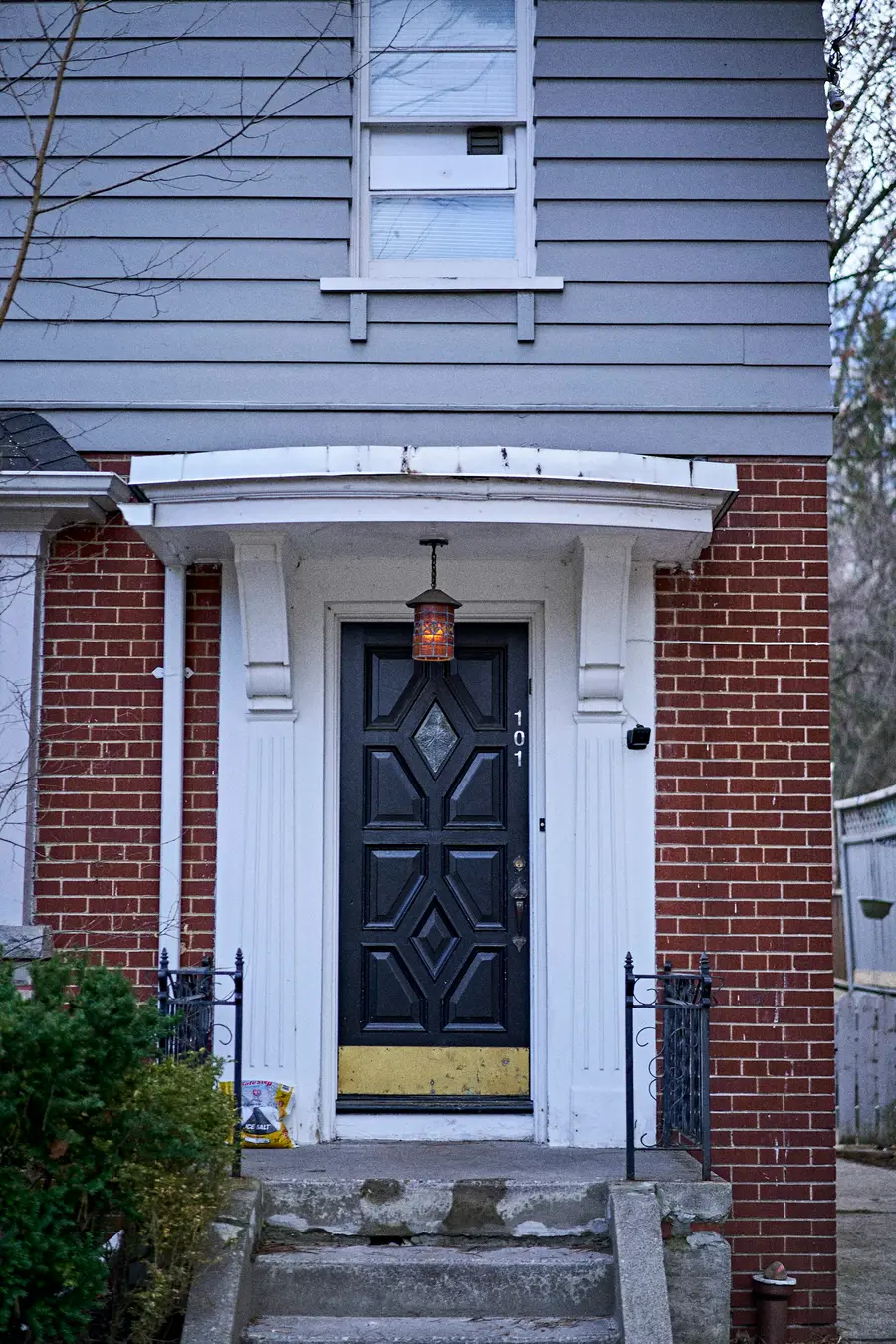 Red brick house with a white porch surround and a dark panelled front door