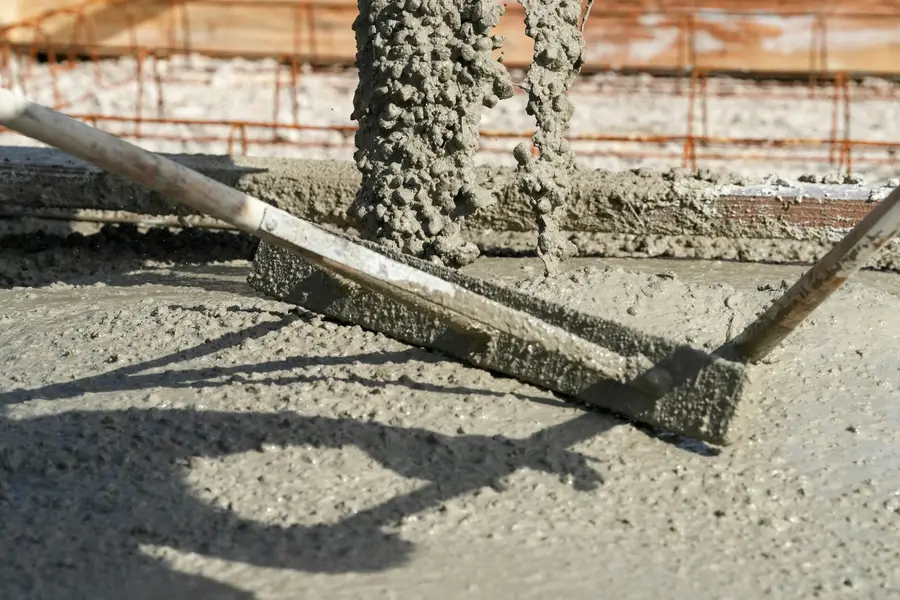 Fresh concrete being levelled with a screed board