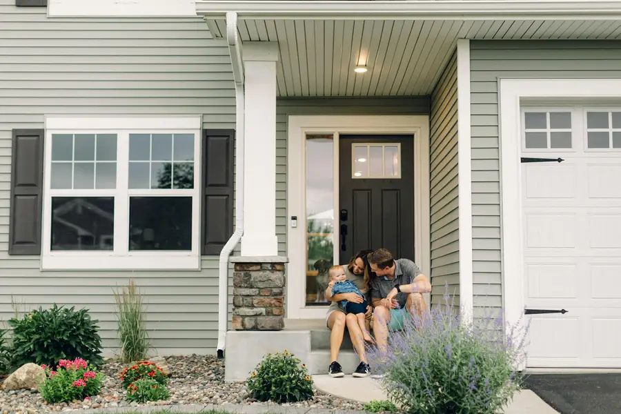 Couple sitting together on the front steps of their house