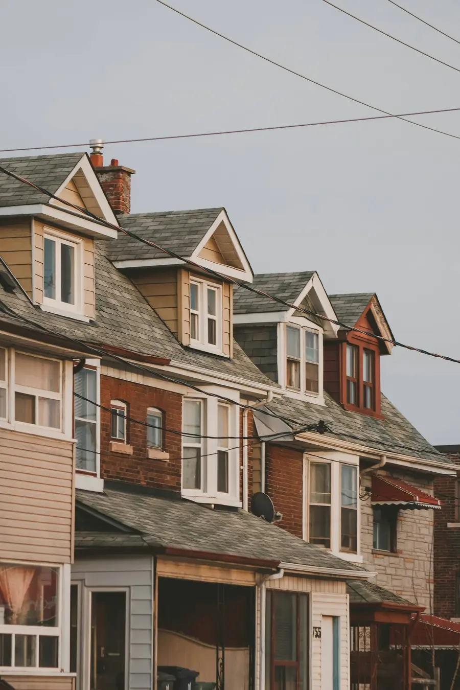 Row of brick and siding houses with pointed dormers