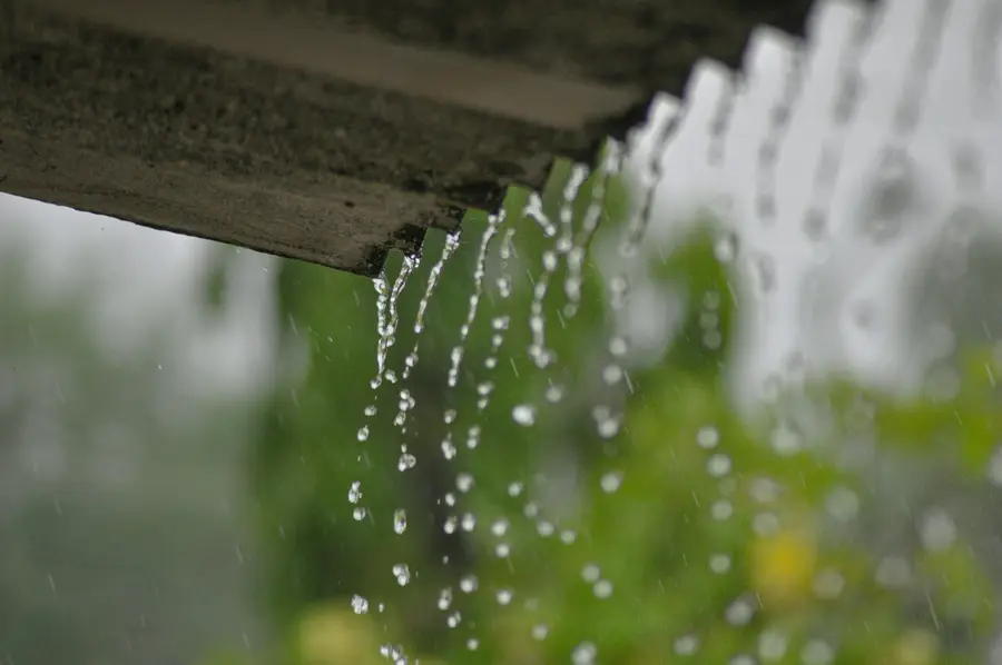 Rainwater dripping from the edge of a roof without an eavestrough