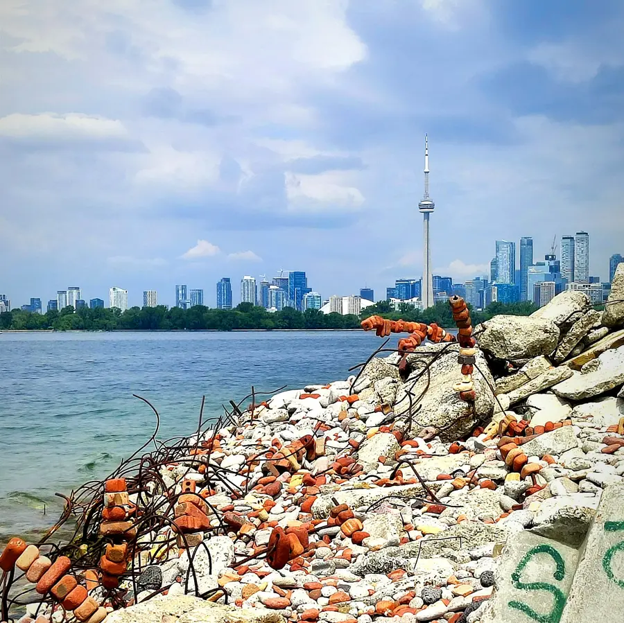 Toronto skyline seen from a rocky Lake Ontario shoreline